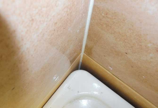  приклеить пластик к кафелю в ванной: уголок между ванной и стеной .